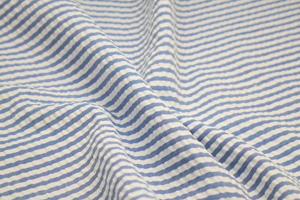 Close detail of softly folded blue-and-white seersucker fabric